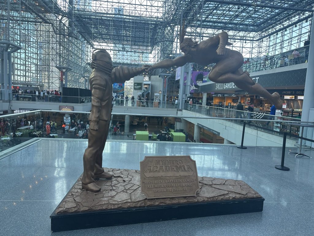 Bronze statue of All For One from My Hero Academia, standing up straight while stopping All Might's jumping fist attack with a single hand. The plaque says "My Hero Academia" in the logo font, with "Historical Battle in Kamino, All Might vs All For One Season 3 Episode 48" below.